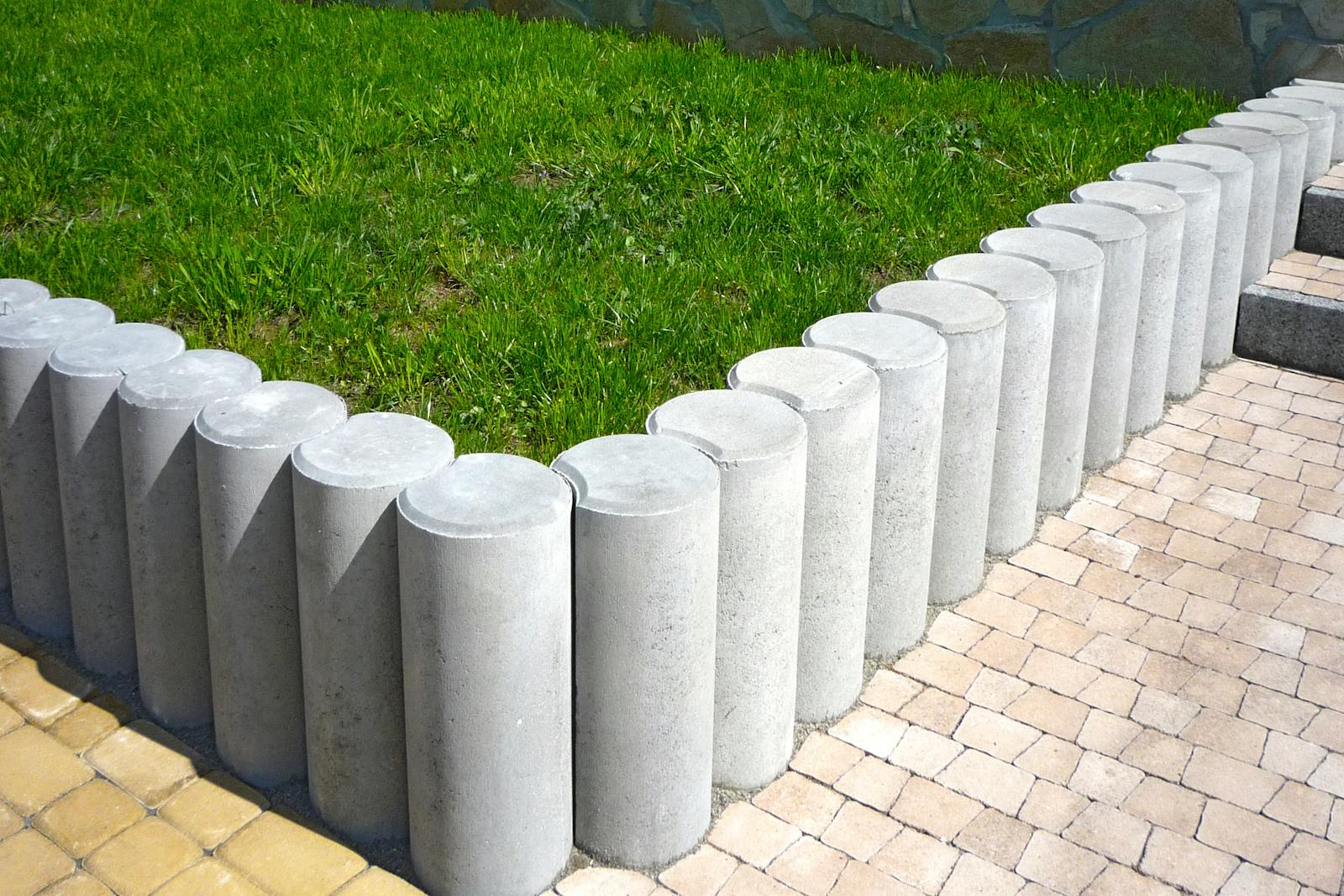 Concrete edging separating a mowed lawn from a mulched flowerbed.